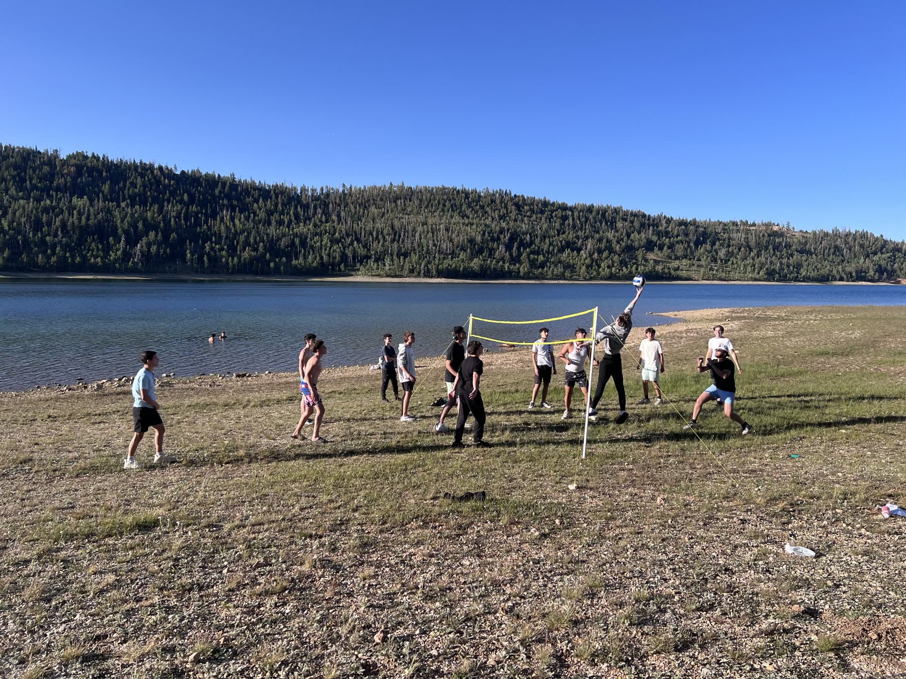 Group playing volleyball on the lakeshore