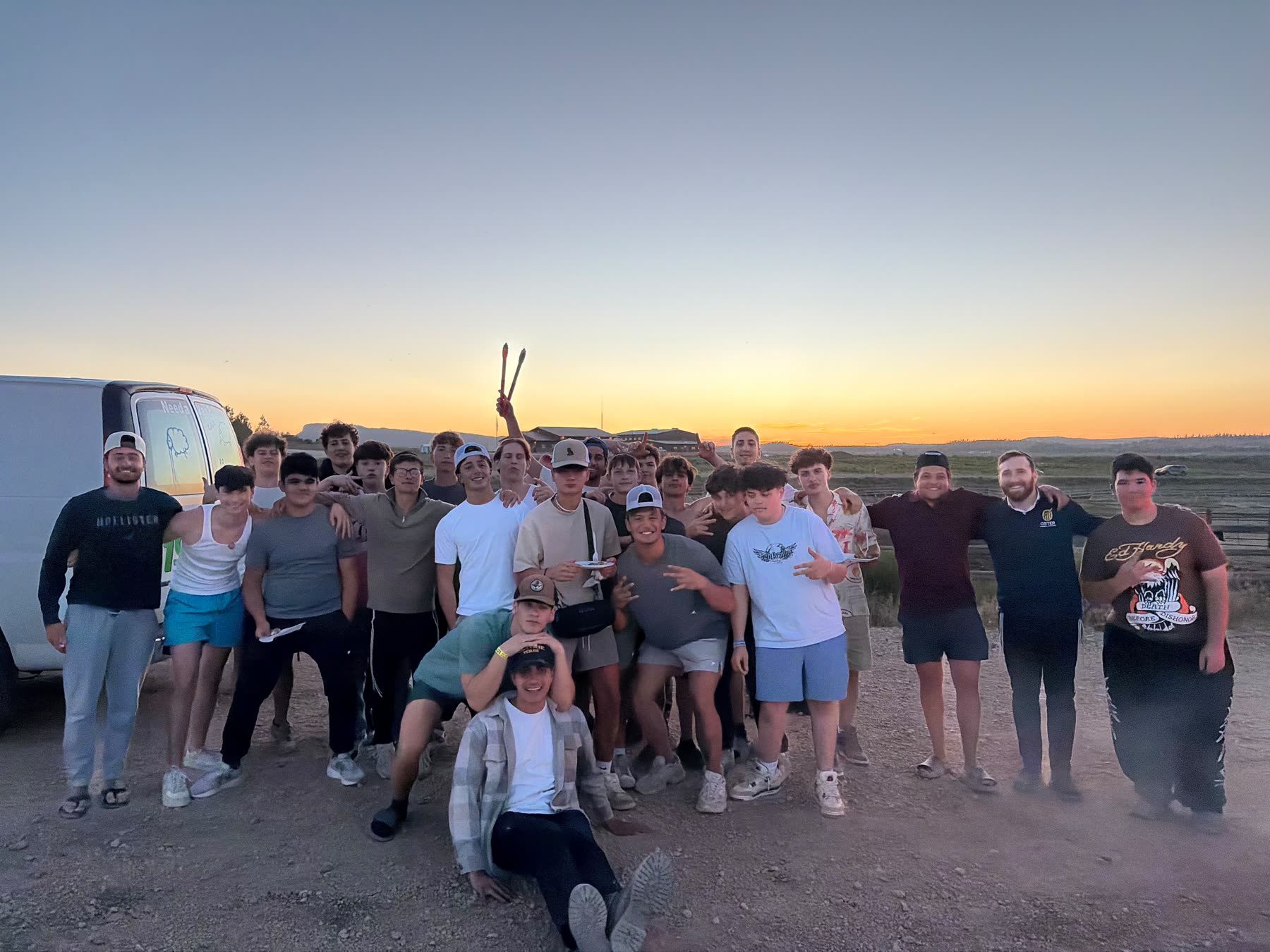 Group with sparklers at sunset next to a van